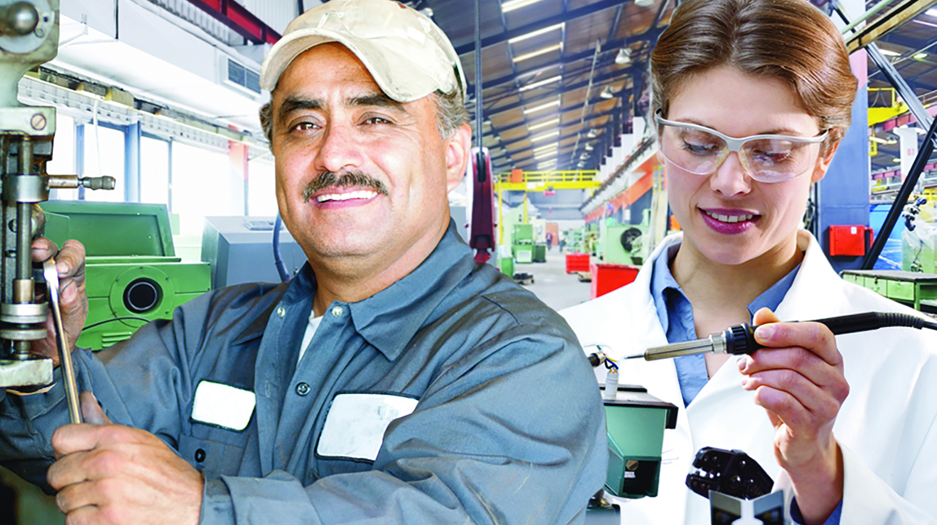 Mann und Frau in Arbeitskleidung in einer Produktionshalle zur Bebilderung des Dienstleistungsbereiches Industrie