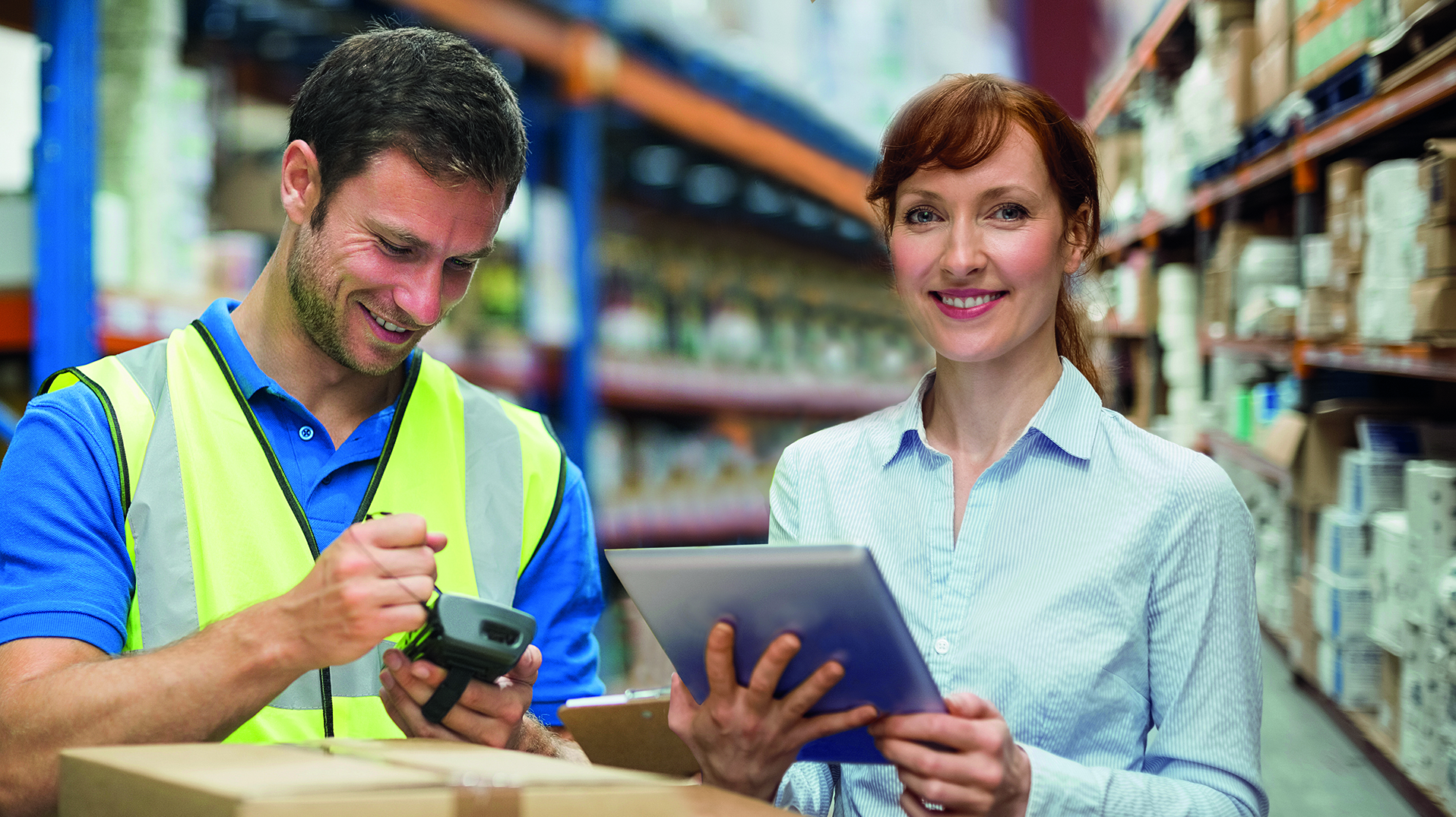 Mann und Frau mit elektronischen Geräten in einem Lager zur Bebilderung des Dienstleistungsbereiches Logistik